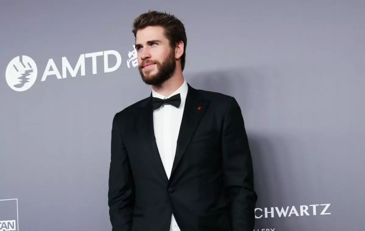 Liam Hemsworth te montre yon foto nan yon kay boule